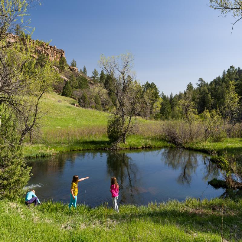 Picture of kids pointing next to a lake.