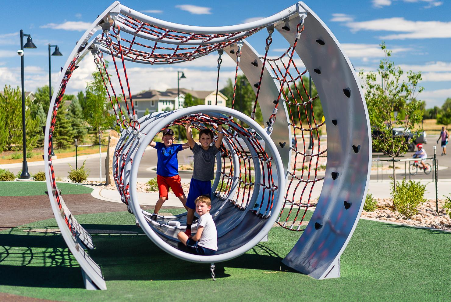 Three youth play in playground structure.