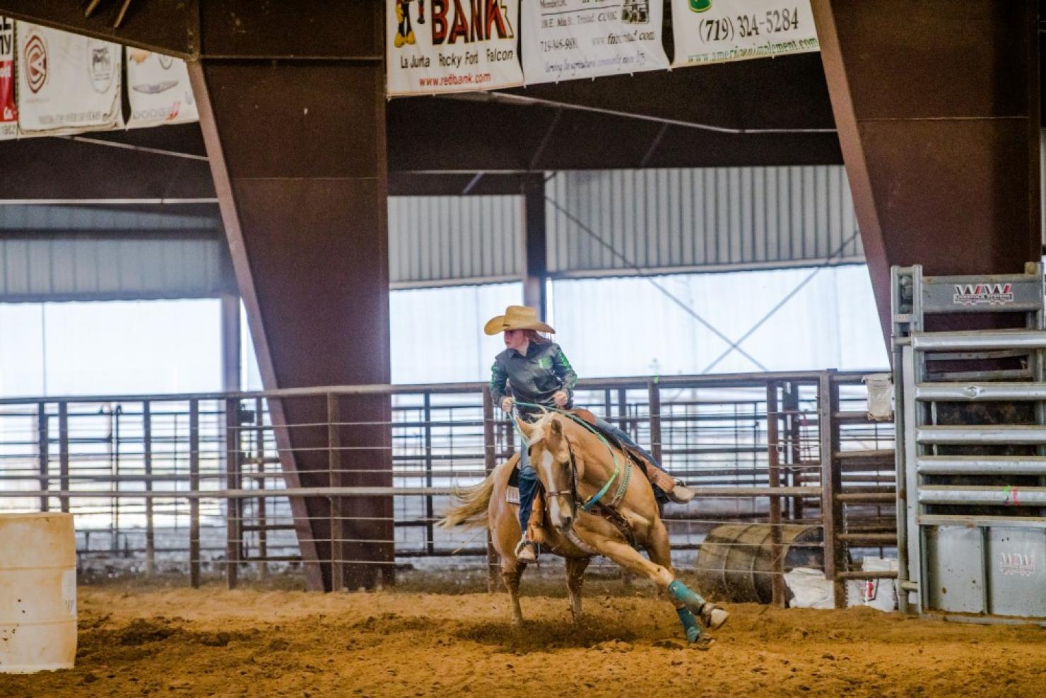 A barrel racer rounds a turn on her horse during the Little Britches Rodeo in Kim, Colorado. Photo by Moxie82 Inc.