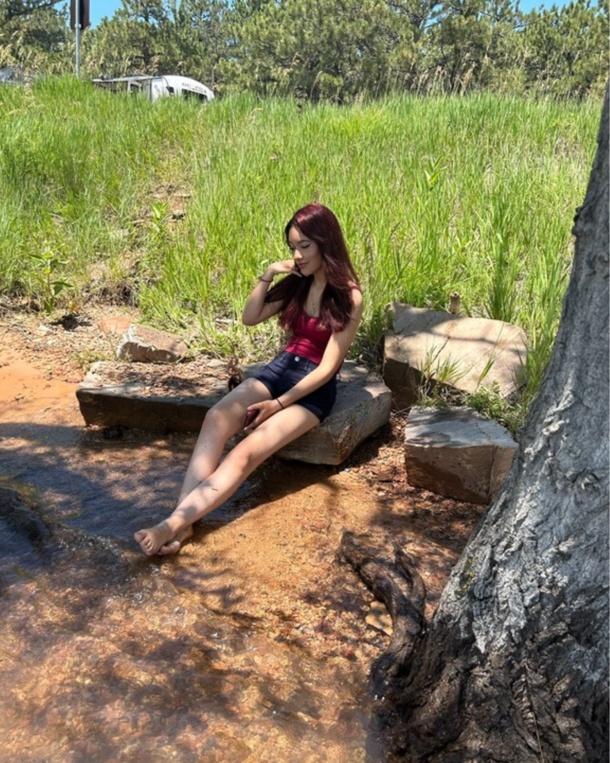 Daniela Carrillo on a rock near a river.