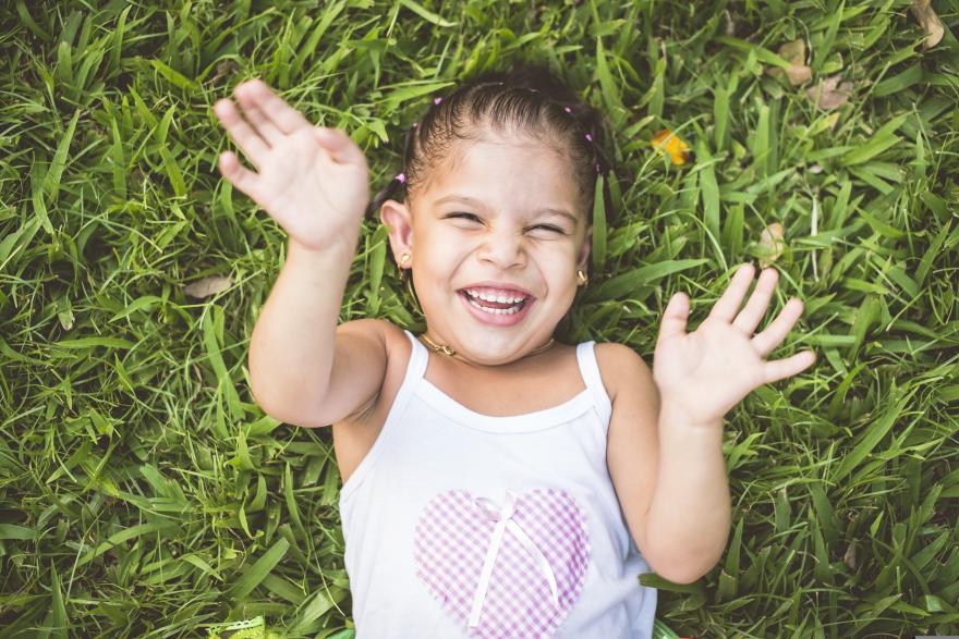 Young girl lays down in the grass. 