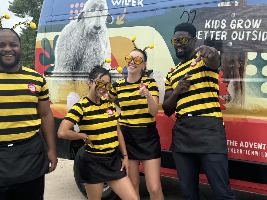 Four event staff members dressed in bee-themed attire. 