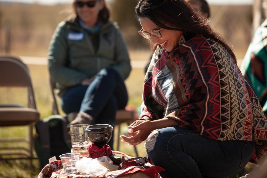 Olga Gonzales, the event facilitator demonstrates a smudging practice to “remove heaviness” for the participants in the talking circle.