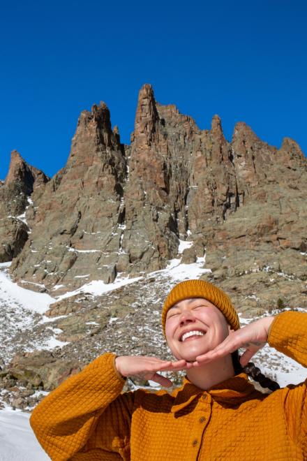 Close up of Kylie Yang posing and smiling in front of a mountain backdrop during winter